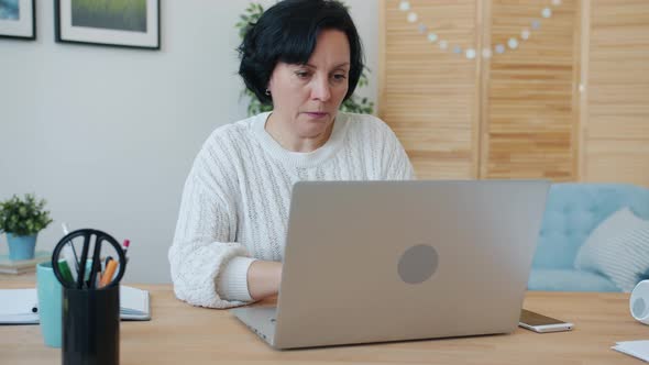 Tired Woman Freelancer Working with Laptop Typing Then Touching Face Feeling Exhausted Indoors at