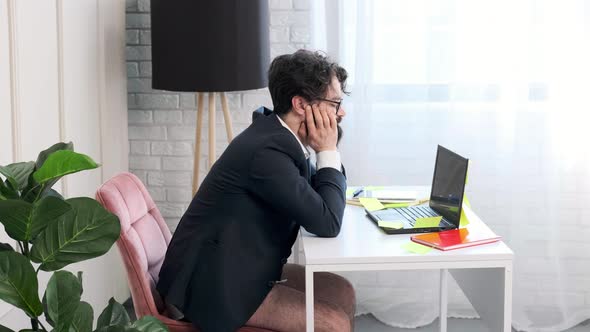 Bearded Man with No Pants Having a Video Call Conference Man is Tired and Falls Asleep