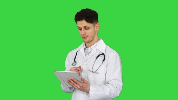 Doctor Holding Digital Tablet Pc and Reading Results on a Green Screen, Chroma Key.