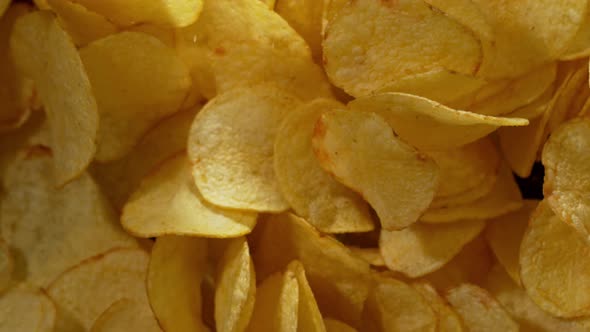 Super Slow Motion Shot of Potato Chips Flies After Being Exploded Against Black Background, 1000Fps.