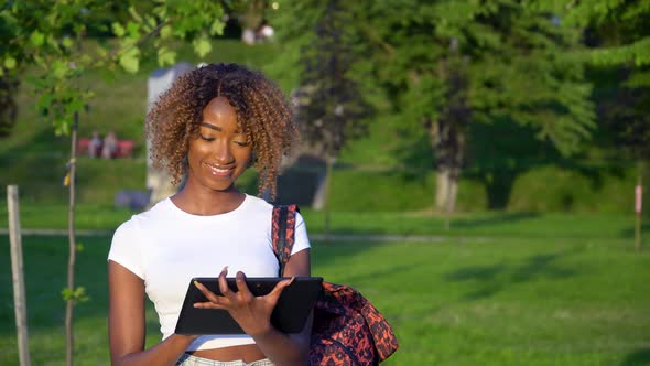 Young African American Female Student Using Tablet in University Park