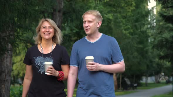 Mother and Adult Son Walking in a City Park