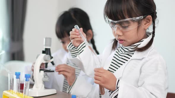 lovely sisters enjoy experimenting with liquids in science class