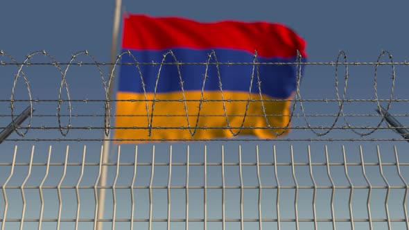 Waving Flag of Armenia Behind Barbed Wire Fence