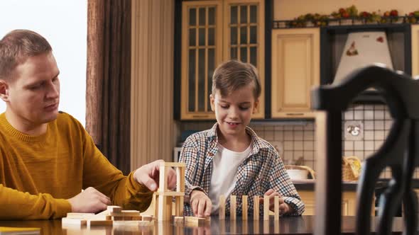 Caucasian man and his son playing with wooden construction set