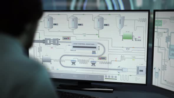 Technician Controls Conveyor Machinery With Automated Factory Software