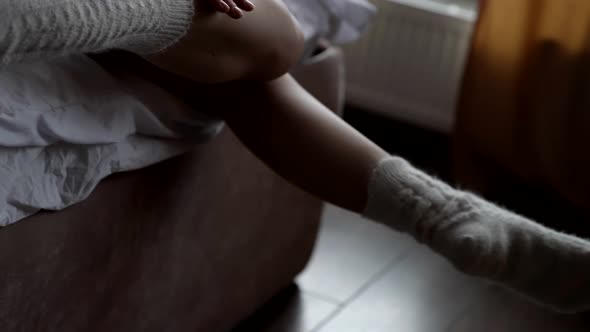 Sexy Female Legs Pose Gracefully on the Bed in the Hotel Room Near the Window Wearing a Light Wool