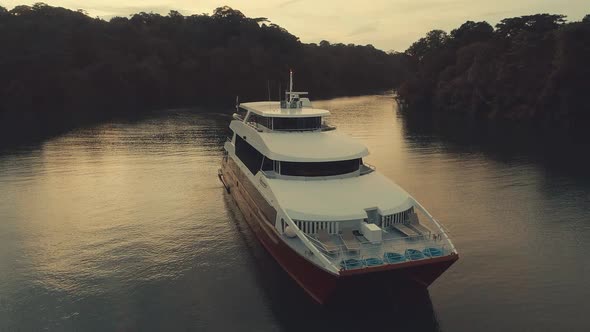 Drone footage during sunset from an elegant boat anchored at big river