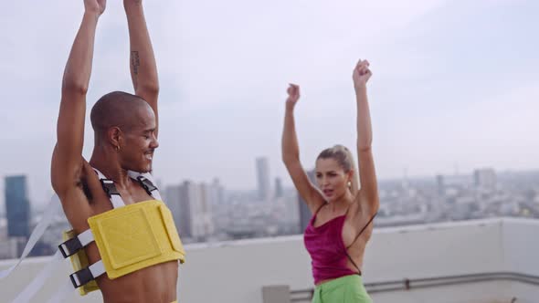 Dancers In Clubwear Spinning And Dancing Together On Skyscraper