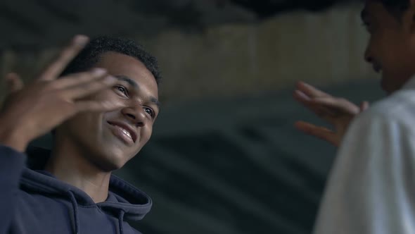 Two Afro-American male friends smiling and bumping fists