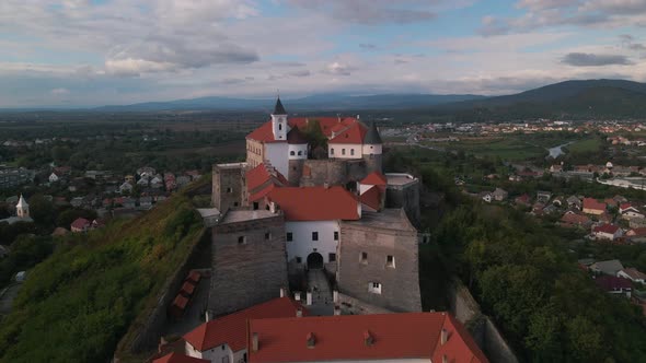 Aerial view of medieval castle on mountain in small european city at cloudy autumn day