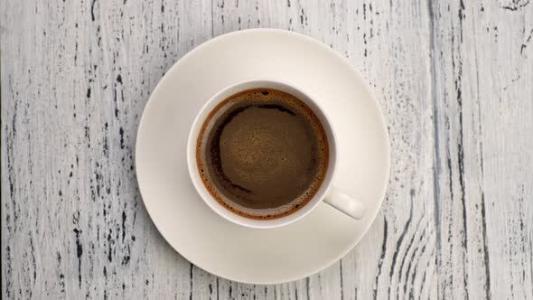 Perfect Breakfast. Black Frothy Coffee in White Cup Over Wooden Grunge Background. Top Down View