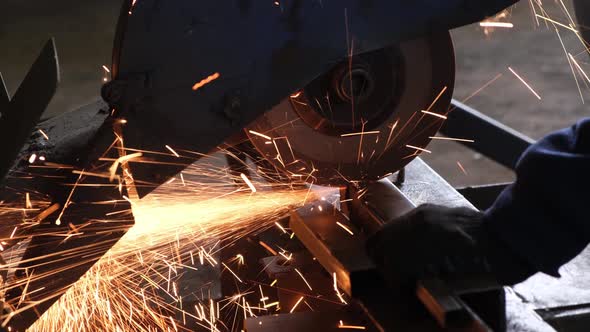 Man cuts metal with a circular saw, sparks flying from the saw blade