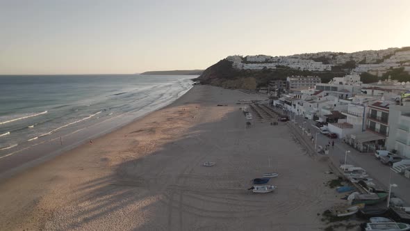 Aerial dolly in shot capturing beautiful white washed buildings townscape from Salema beach.