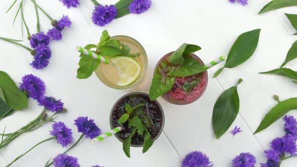 Different Delicious Fresh Fruit Lemonades with Sparkling Water on Wood White Background