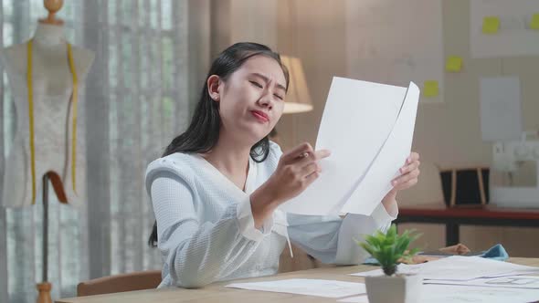 Upset Asian Woman Bag Designer Positively Shaking Her Head While Looking At The Layout Bond