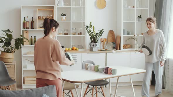 Two Young Women Playing Ping Pong with Kitchenware at Home