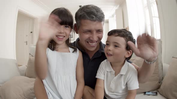 Happy Dad and Two Cute Kids Smiling and Waving Hello at Webcam