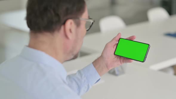 Man Holding Smartphone with Green Chroma Key Screen