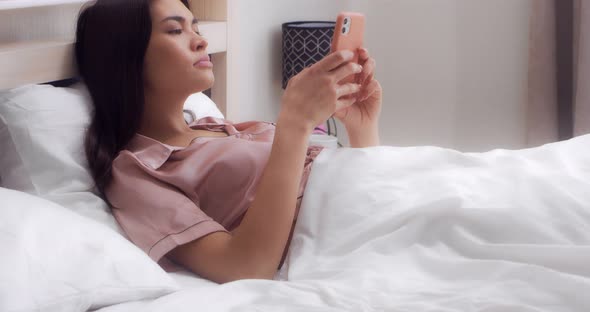 Woman is Shocked By What She Read in Messenger While Lying in Bed in the Bedroom