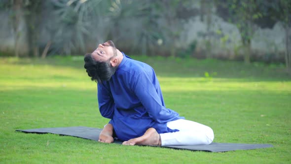 Indian man doing Supta Vajrasana or Lying thunderbolt Yoga Pose or Sleeping thunderbolt Yoga Pose