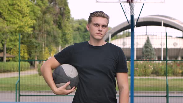 Portrait of Male Basketball Players Resting After Game. Handsome Young Man with Ball Standing After