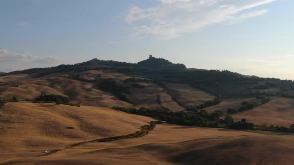 Flying towards a castle on the hill at sunset, Tuscany, Italy, Europe