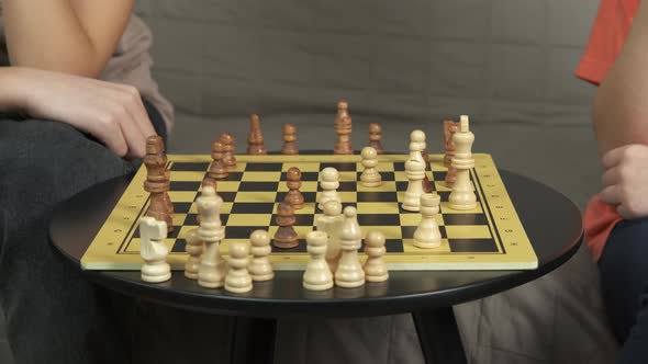 Chess playing by smart table in living room. 