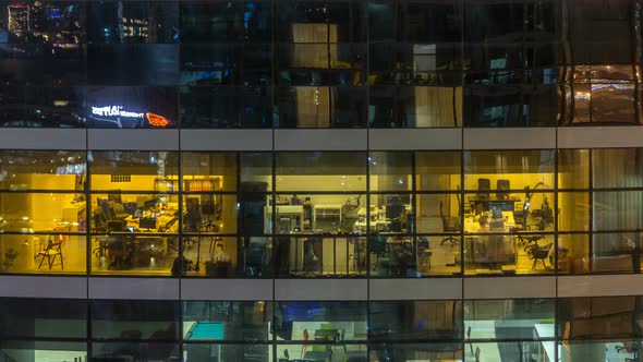 Glowing Windows in Multistory Modern Glass and Metal Office Building Light Up at Night Timelapse