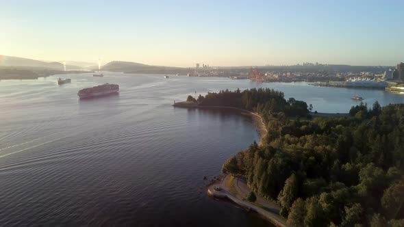 Large Cargo Ship Transporting And Sailing At The Burrard Inlet During A Bright Sunrise in Vancouver,