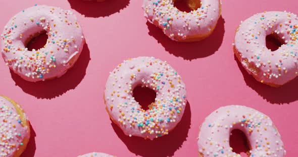 Video of donuts with icing on pink background