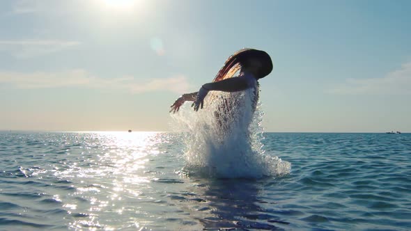 Strength Man Bathing in Sea Playing Long Hair Surrounded By Splashing at Sunset Slow Motion