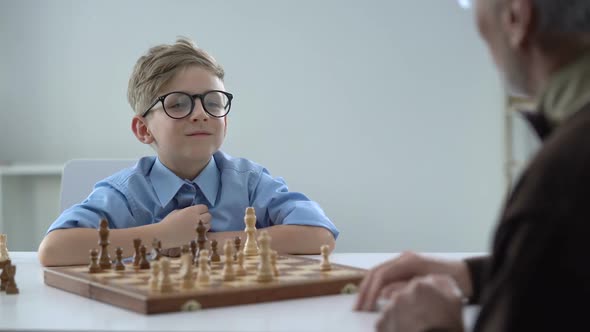 Handshake of Senior Man and Little Boy Playing Chess Genius Kid Respects Teacher