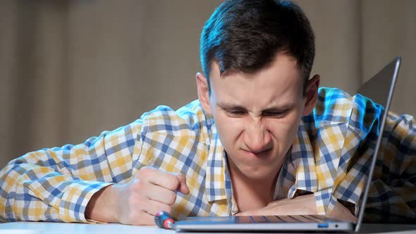 Young Man Knocking on Laptop and Getting Angry