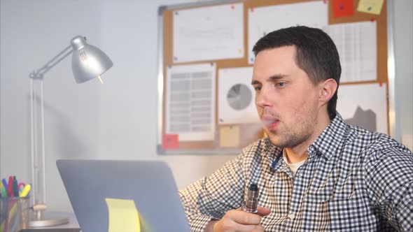 Smoking Electric Cigarettes at Workplace in Office.