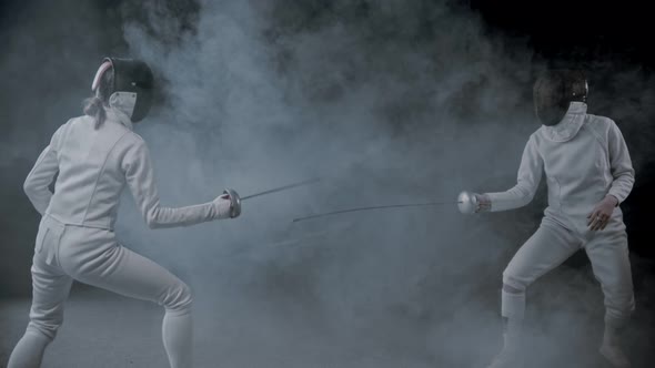 Fencing Training - Two Women Having a Duel in the Smoky Studio