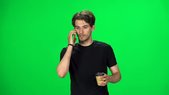 Brunette Man Walking Talking on the Phone and Drinking Coffee. Chroma Key. Slow Motion