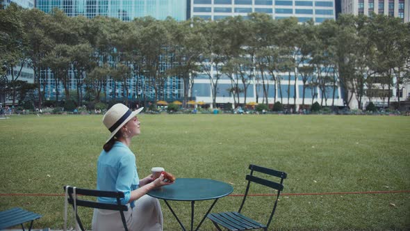 Attractive woman having breakfast in the park