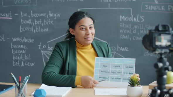 Language School Teacher Working Online Recording Lesson with Video Camera in Modern Office alt