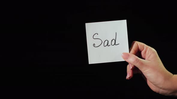 Man Burns a Paper with the Inscription Sad