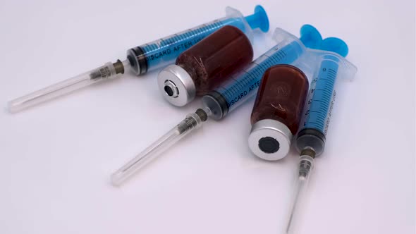 Vaccine bottle with red solution with syringe