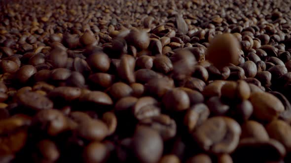 Closeup Coffee Beans Falling Down on Large Heap with Camera Going Forward