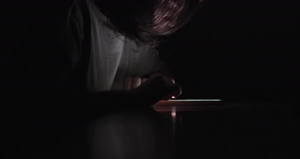 Woman Is Using Swiping Phone In Complete Dark. Fixing Her Hair.