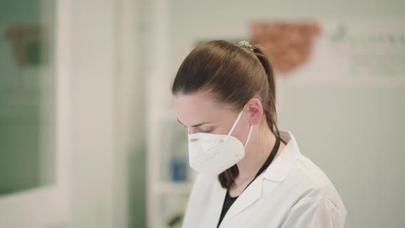 Medical Researcher Wearing Facemask And Laboratory Gown.  medium shot