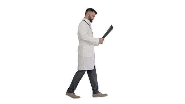 Medical Doctor Walking and Looking at Xray Picture of Lungs on White Background