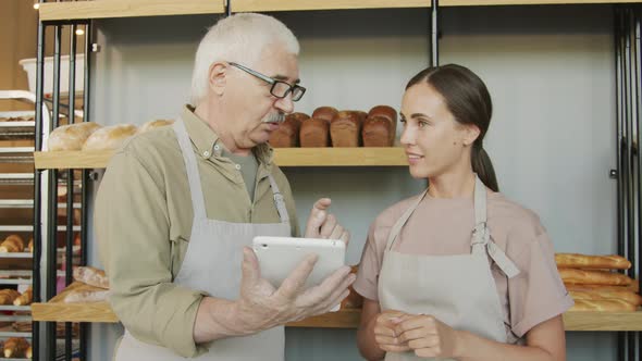 Elderly Baker and Shopkeeper Talking in Bakery