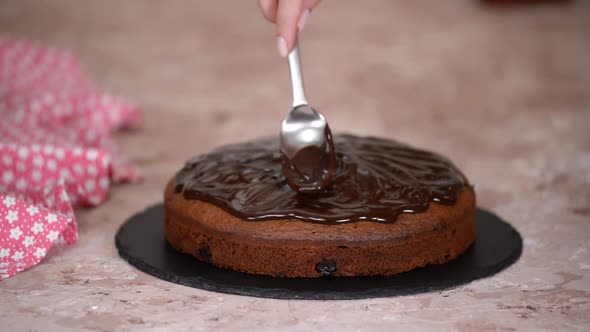 Spreading Chocolate Sauce on Top of Cherry Cake