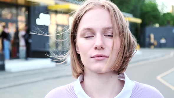 Cheerful Young Woman with Short Hair Waved By Light Wind