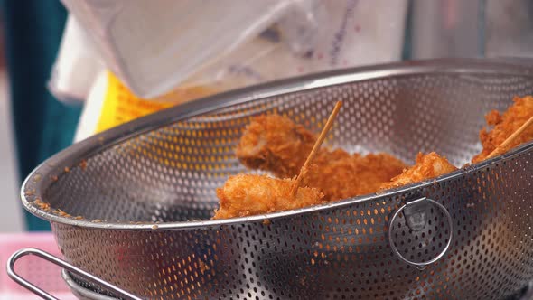 Street Food in Asia - Breaded Chicken Sticks Left to Drain in a Metal Bowl