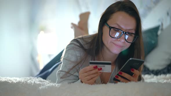 Woman Makes Online Payment at Home with a Credit Card and Smartphone